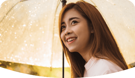 Smilling young woman holding an umbrella on a rainy day